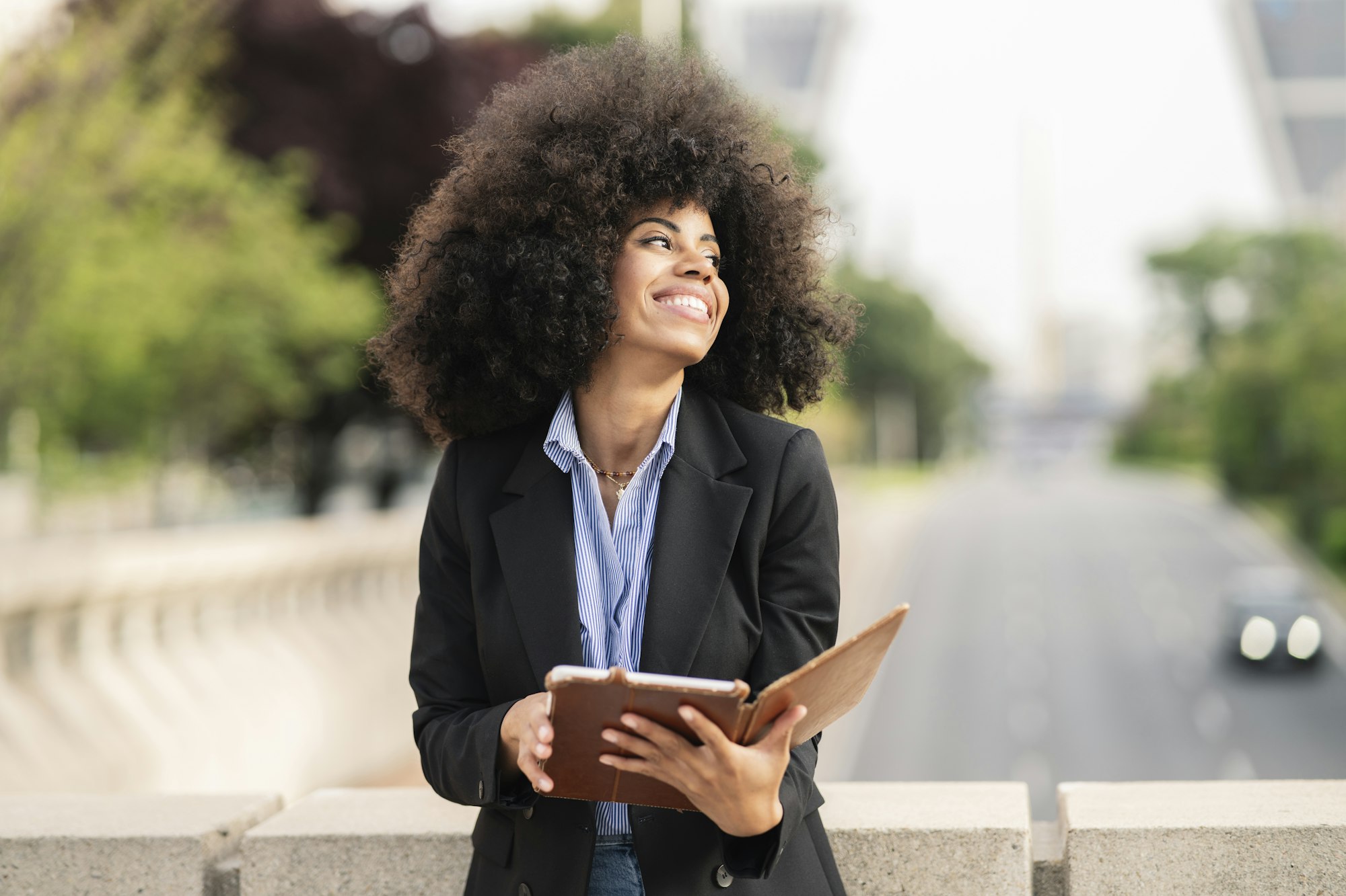 afro american woman reading a book in the city -digital book concept-